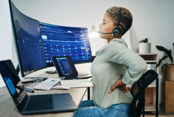 Woman cracking her back while working on a desk