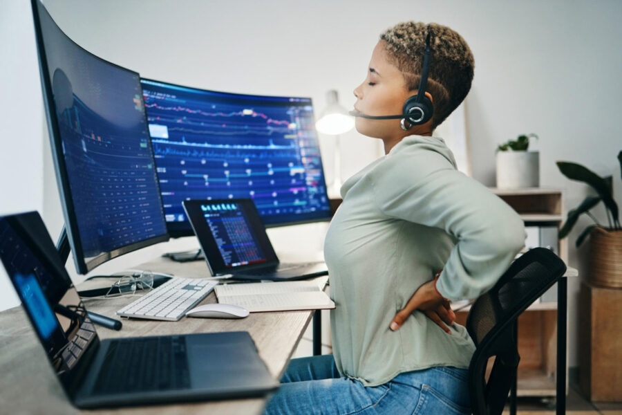 Woman cracking her back while working on a desk